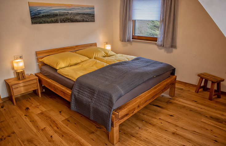 Ferienhaus Enztalblick in Enzklösterle im Nordschwarzwald - Das Schlafzimmer im Obergeschoss mit Balkenbett aus massivem Eichenholz